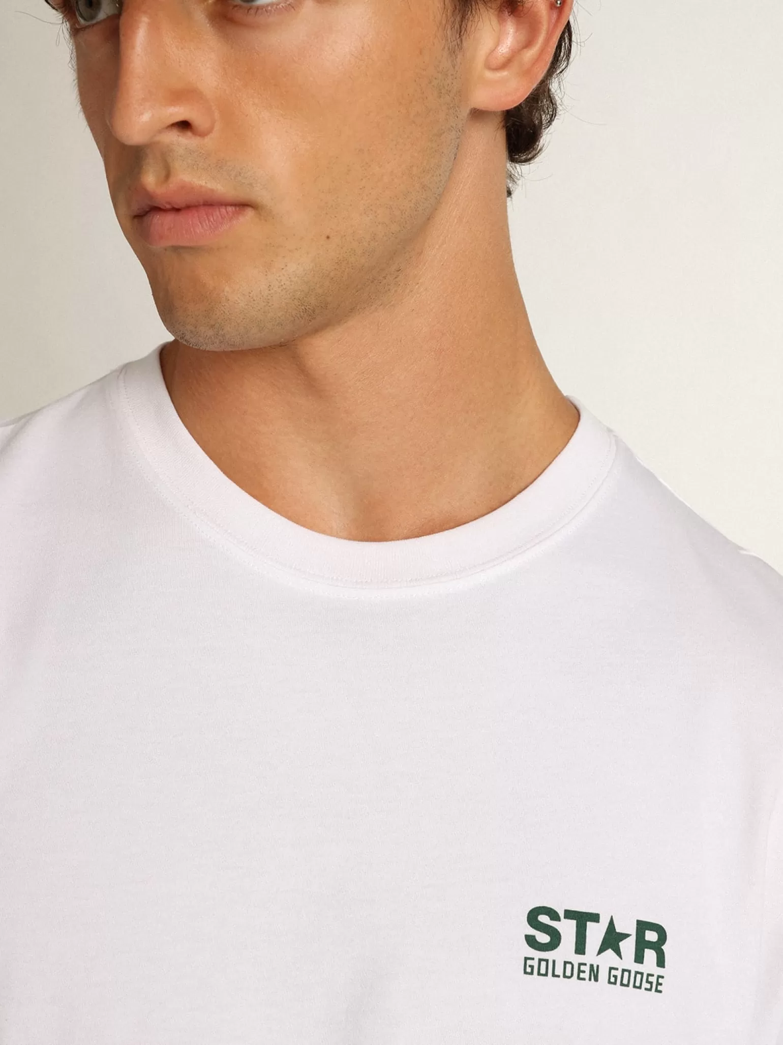 Store Camiseta masculina branca com logo e estrela verdes em contraste Camisetas